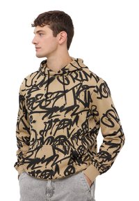 Felpa beige con un motivo in stile graffiti nero, dotata di una tasca frontale e cappuccio con cordino. Tessuto morbido e design casual.