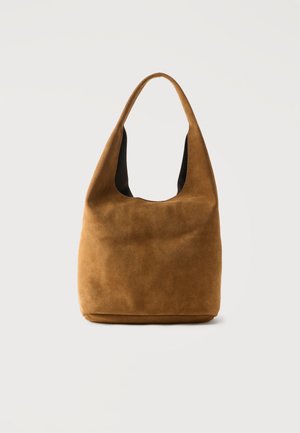 Pruun seemisnahast hobo-kott laia rihma ja pehme, lõdva kujuga, esitatud ühevärvilise heleda tausta ees.