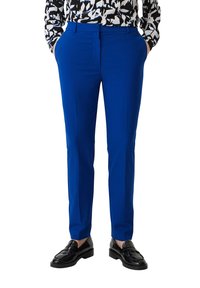 Dopasowane niebieskie spodnie o gładkiej fakturze, z bocznymi kieszeniami i płaskim przodem, w połączeniu z czarnymi mokasynami.