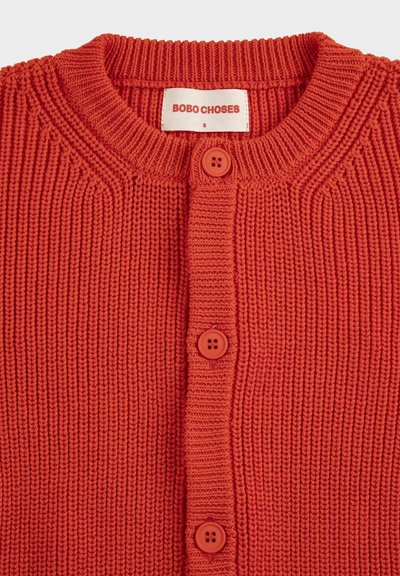 Cardigan rouge en tricot avec col rond, devant boutonné, et étiquette "BOBO CHOSES" à l'intérieur du col, taille petite.