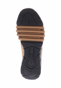 Bruine suede en rubber schoen met een gestructureerde zwarte zool die een gegroefd patroon en verhoogde secties voor grip bevat. Goed gedefinieerde hak en voetboog.