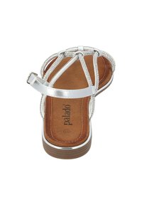 Srebrne sandały na płaskiej podeszwie, z teksturowaną brązową wkładką i dekoracyjnymi srebrnymi plecionymi paskami. Zawierają regulowany zamek na kostce.