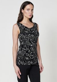 Haut sans manches noir avec des motifs floraux et paisley en vert et blanc, encolure drapée, tissu texturé, design ajusté.