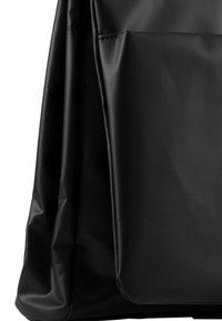 Bolso negro hecho de un material liso y duradero. Presenta un bolsillo frontal y pliegues suaves, con un diseño minimalista y sin herrajes visibles.