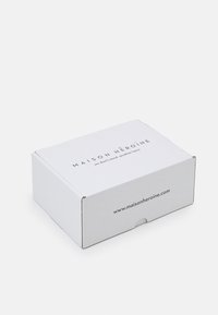 Boîte en carton blanc avec une finition mate. Présente du texte imprimé sur le dessus et le côté, y compris le nom de la marque et l'adresse du site web.