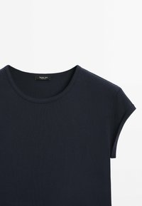 T-shirt bleu marine foncé à manches courtes avec col rond et étiquette visible à l'intérieur du col sur fond blanc.
