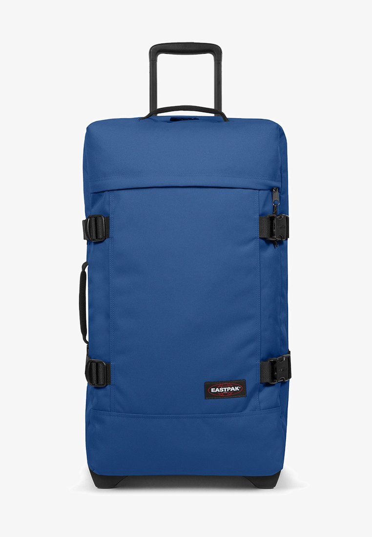 Modrý kufr na kolečkách s pevným madlem, plastovými nožičkami a nastavitelnými popruhy. Vyroben z odolné tkaniny, s uzavíráním na zip na vrchu.