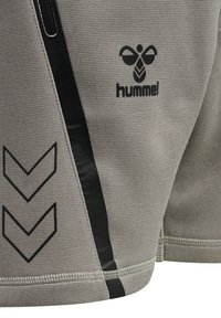 Grau sportliche Shorts aus strukturiertem Stoff, mit einem schwarzen Seitenpanel und einem Chevron-Muster. Das Markenlogo "hummel" ist sichtbar.