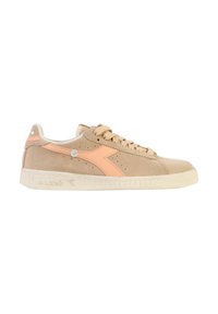 Baskets en daim beige avec un accent de logo rose clair et une semelle en caoutchouc blanche. Présente une pointe arrondie et des lacets plats. Détails perforés minimalistes.