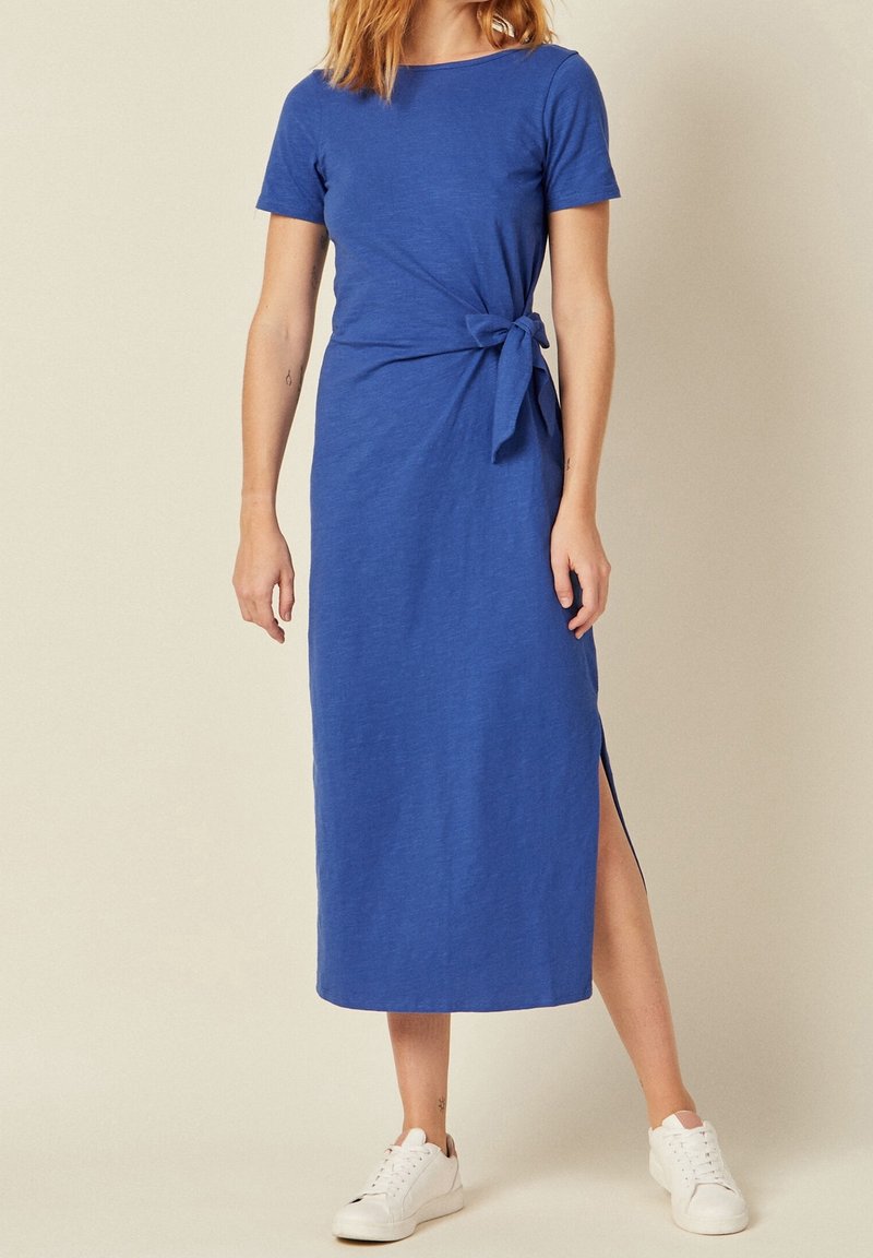 Vestido azul hasta la rodilla con mangas cortas, abertura lateral y un lazo anudado en la cintura. Hecho de material suave y texturizado.