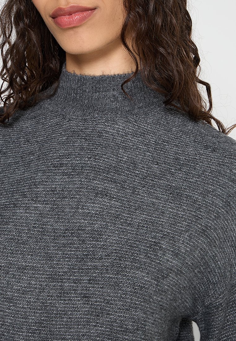 Grauer Strickrollkragenpullover mit einem strukturierten Muster, hohem Kragen und lässiger Passform, geeignet für Schicht-Outfits.