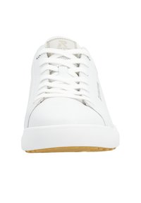 White leather sneakers with a rounded toe, flat white laces, and a gum rubber sole. Minimalistic design, features brand logo on the side.