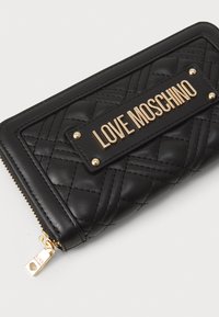 Carteira preta de couro sintético acolchoada com logotipo "LOVE MOSCHINO" em tom dourado, tachas redondas e fecho de correr com puxador em forma de coração.