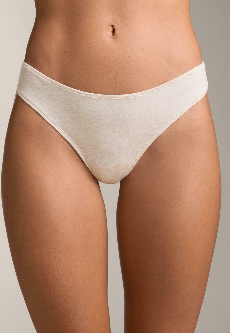 Beige nahtloser Tanga mit einem breiten, weichen Taillenbund, hergestellt aus einem glatten Stoff, mit subtiler Textur und einem minimalistischen Design.