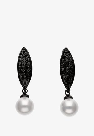 Fekete fém fülbevalók, textúrált levél alakú tetejükkel és alul lógó fehér gyöngyükkel. A dizájnja sima és fényes felületekkel rendelkezik.