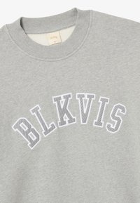 Jasnoszara bluza z okrągłym dekoltem z białym haftowanym napisem "BLKVIS" w łuku na piersi, pokazana na płasko na białym tle.