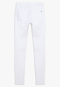 Jeans blancos ajustados hechos de una mezcla de algodón, con dos bolsillos traseros, una etiqueta de logo en la cintura y un acabado suave y limpio.