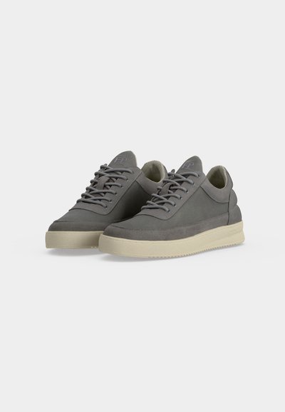Paire de baskets basses grises avec semelles et lacets beige clair, présentée sur fond blanc uni.