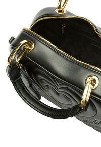 Sac à main en cuir noir avec motif matelassé en forme de cœur, ferrures dorées, deux poignées supérieures et une ouverture zippée. L'intérieur est doublé d'un tissu uni.