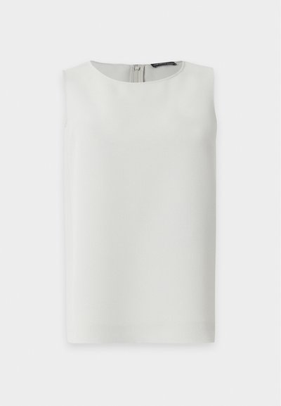 Blouse blanche sans manches avec encolure ronde et fermeture éclair visible dans le dos, présentée sur fond blanc uni.
