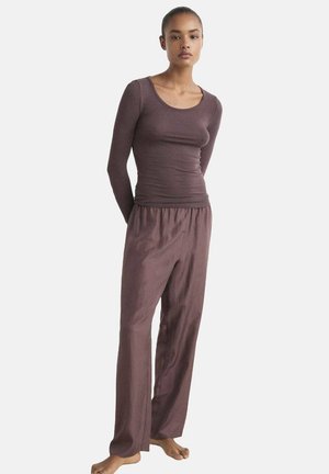 Top burdeos de manga larga con escote redondeado, combinado con pantalones sueltos a juego. Ambas prendas tienen una textura suave y un ajuste relajado.