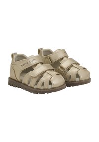 Guldiga lädersandaler med stängd tå, öppna sidor, två justerbara kardborreband och en strukturerad brun gummisula.