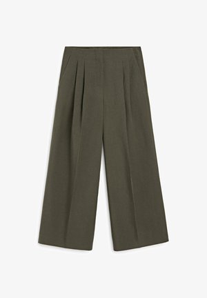 Pantalon large vert olive avec plis sur le devant et poches latérales, taille plate et apparence lisse et ajustée.
