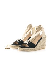 Sandali con zeppa in suede nero, con punta aperta, lacci bianchi e dettagli in juta intrecciata. Fibbia in tessuto chiaro alla caviglia e suole testurizzate.