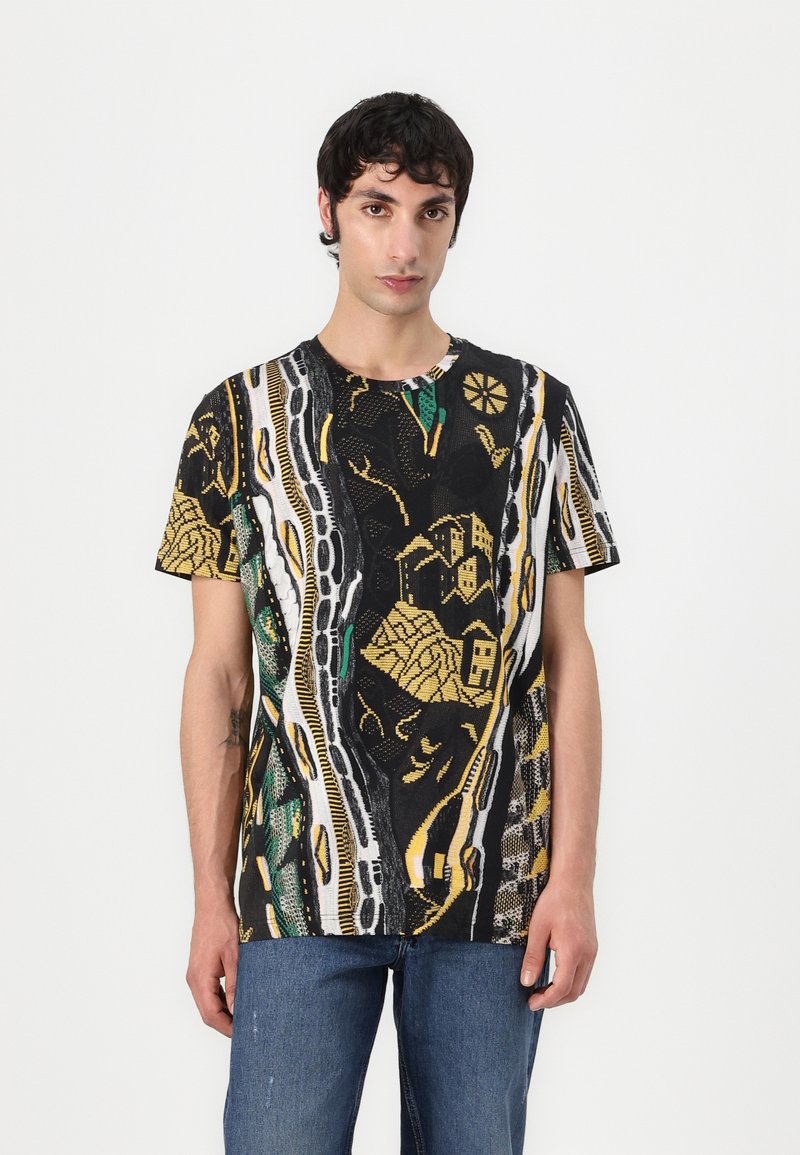 T-shirt preta de manga curta com um padrão geométrico em amarelo, verde e branco, com detalhes texturizados e um decote redondo.
