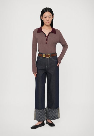 Tumši sarkana ribota garām piedurknēm polo krekls ar trim pogām, kopā ar tumši džinsa platajiem biksēm ar rakstainām aprocēm un brūnu jostu. Melnas dzīvokļbikses.