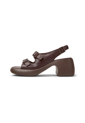 Brun læder sandal med åben tå og chunky hæl, tre justerbare spænderemme og slingback-design på hvid baggrund.