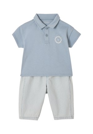 Hellblaues Poloshirt mit kurzen Ärmeln und kleinem Sonnenmotiv, kombiniert mit knieumspielenden Shorts in blassblau-weiß gestreift.