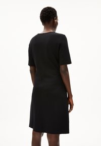 Schwarzes kurzärmliges Kleid mit rundem Ausschnitt, figurbetontem Oberteil und schwingendem Saum. Glatte Textur mit minimalen Details und klaren Linien.