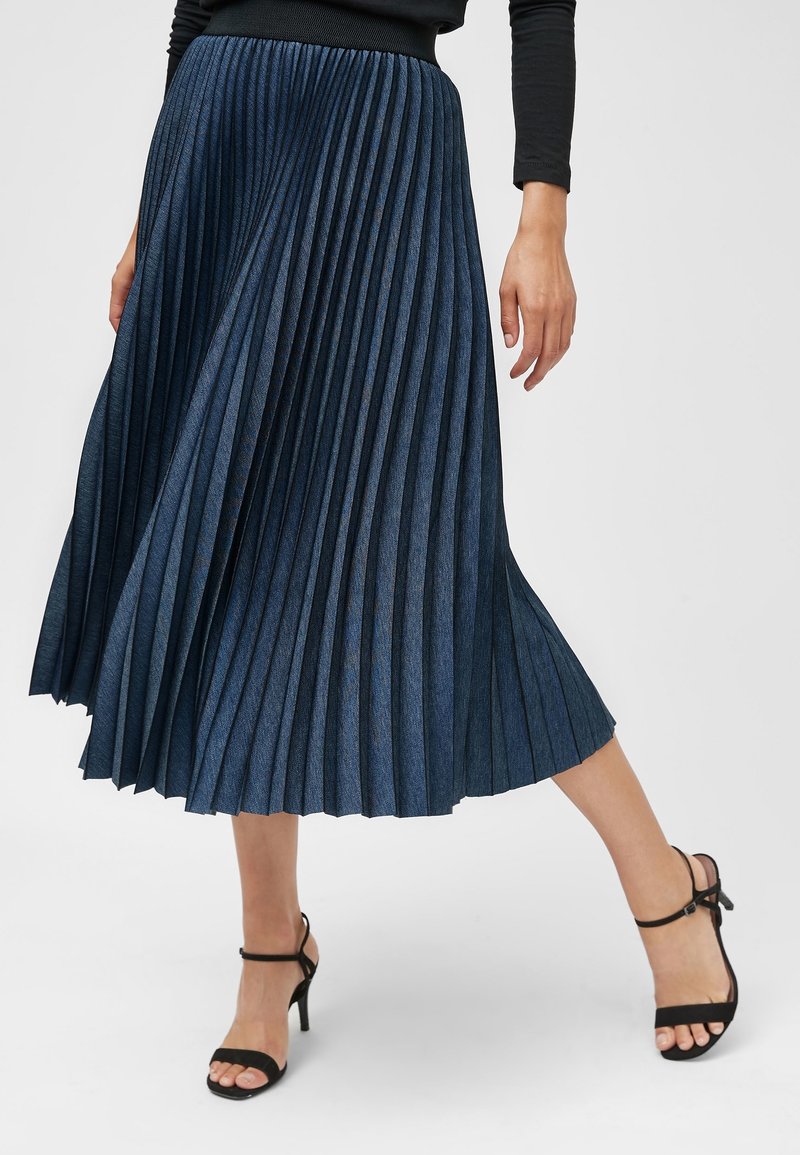 Plissédenimrok in diepblauw, met een brede elastische tailleband, vloeiende pasvorm en zachte textuur met een subtiele glans.
