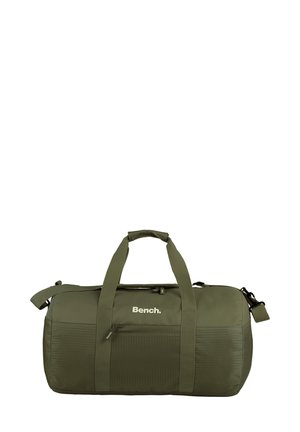 Sac de sport vert olive avec deux poignées de transport et une bandoulière réglable. Comprend une poche zippée à l'avant et des accents en panneaux texturés.