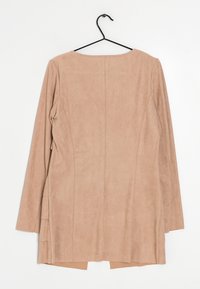 Beige, suede langærmet top med en rund halsudskæring, sideslids og bagsydetail. Hængende på en sort plastkrog.
