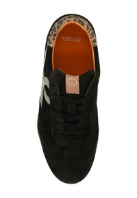 Zwarte suède sneaker met een gestructureerde bruine patroonkraag, vetersluiting en contrasterende zilveren logo-detail aan de zijkant. Oranje binnenzool.