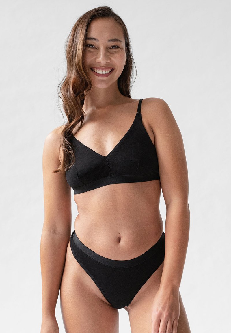 Schwarzer BH mit V-förmigem Ausschnitt, verstellbaren Trägern und elastischem Unterband; passende schwarze hochgeschnittene Unterhose mit glatter Textur.