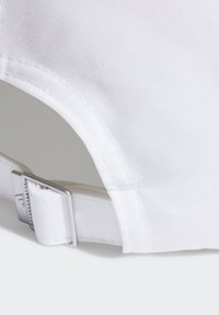 Gorro blanco hecho de tela texturizada, con visera curvada, correa ajustable con herrajes plateados y costuras decorativas a lo largo de los bordes.