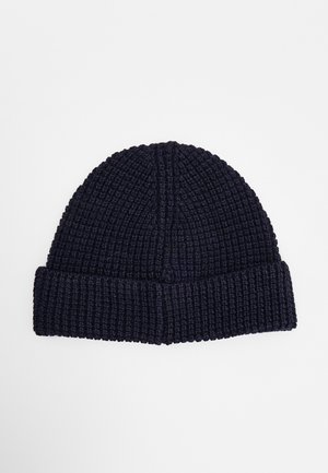 Bonnet en laine noire tricoté avec un revers, présenté à plat sur fond blanc.