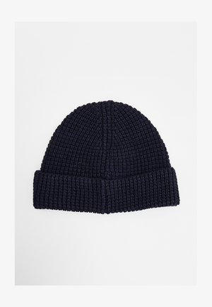 Bonnet en laine noire tricoté avec un revers, présenté à plat sur fond blanc.