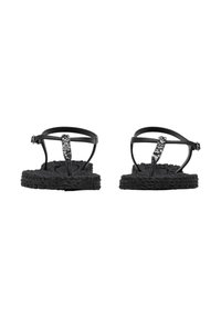 Zwarte platte sandalen met gevlochten gestructureerde zolen en verstelbare enkelbandjes, versierd met een zwarte en zilveren kralen verticale band.