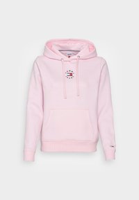 Felpa con cappuccio rosa, dotata di tasca frontale, con un logo circolare che recita "TOMMY JEANS". Realizzata in tessuto morbido con polsini e orlo a coste.