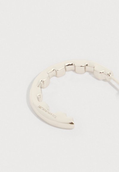 Ασημένιο σκουλαρίκι ημικυκλικής φόρμας με κυματιστή άκρη και τη χάραξη "PATTARAPHAN 925" στην εσωτερική πλευρά.