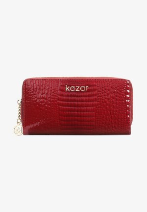 Cartera roja con patrón de cocodrilo hecha de cuero sintético brillante. Cuenta con un logo dorado y cierre de cremallera con un charm decorativo.