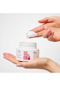 Barattolo bianco con scritte rosse, etichettato "Repair Rescue Treatment Care-Boost Complex". Prodotto cremoso sulla punta del dito, consistenza liscia.