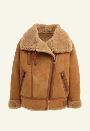 Brązowa kurtka shearling z sztucznym futrem przy kołnierzu, zamek błyskawiczny z przodu i dwie boczne kieszenie. Szczegółowe przeszycia i gładkie skórzane akcenty.