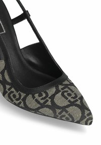 Scarpa con tacco alto a punta, realizzata in tessuto a fantasia beige e nero, con dettagli in pelle nera e un design a taglio laterale.