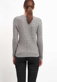 Harmaa kabelineulepaita pitkillä hihoilla, jossa on pyöreä pääntie ja ribbaushelma. Tekstuuriltaan pehmeä ja istuvuudeltaan tiukka.