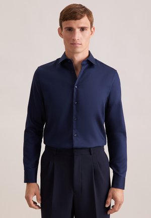 Marineblauw overhemd met lange mouwen, een puntige kraag, knopen aan de voorkant en een gladde textuur; gecombineerd met donkere broeken, eenvoudig ontwerp, zonder patronen.
